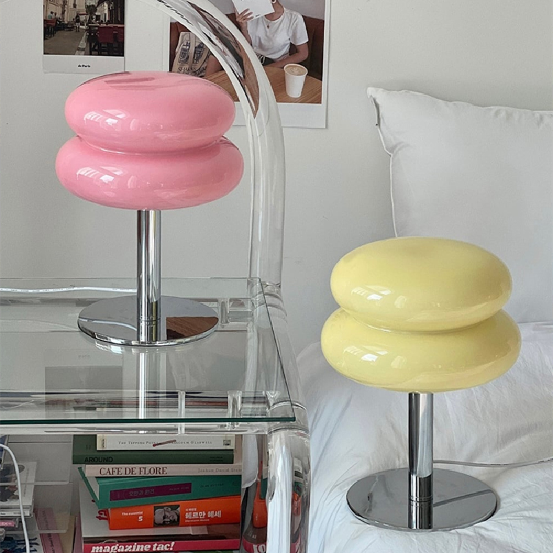 Pink and yellow retro space age glass table lamps with polished chrome bases on a glass side table.