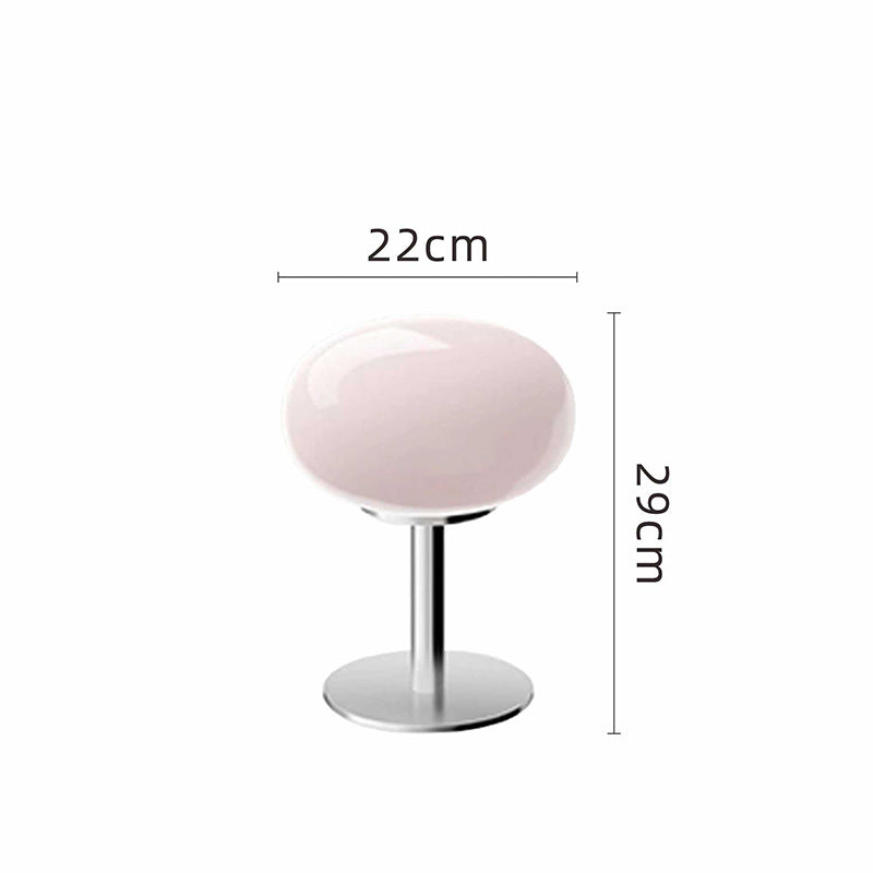Pink retro space age table lamp with a rounded glass shade and polished chrome base, 29cm tall and 22cm wide.