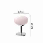 Pink retro space age table lamp with a rounded glass shade and polished chrome base, 29cm tall and 22cm wide.