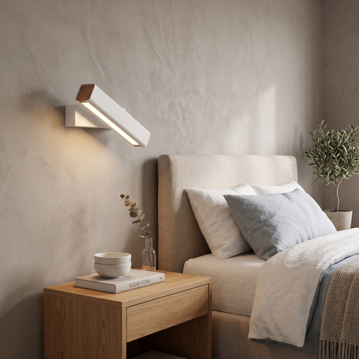 Rotatable LED Wall Light – White in a serene bedroom beside an upholstered headboard and oak nightstand