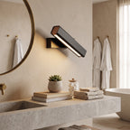 Rotatable LED Wall Light – Black in a spa-like bathroom beside a large round mirror and stone vanity
