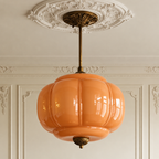 Vintage orange sculpted glass semi-flush ceiling light with antique brass hardware in a classic interior.