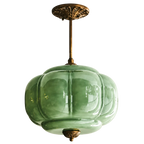 Vintage green sculpted glass semi-flush ceiling light with an ornate antique brass mount and decorative detailing.