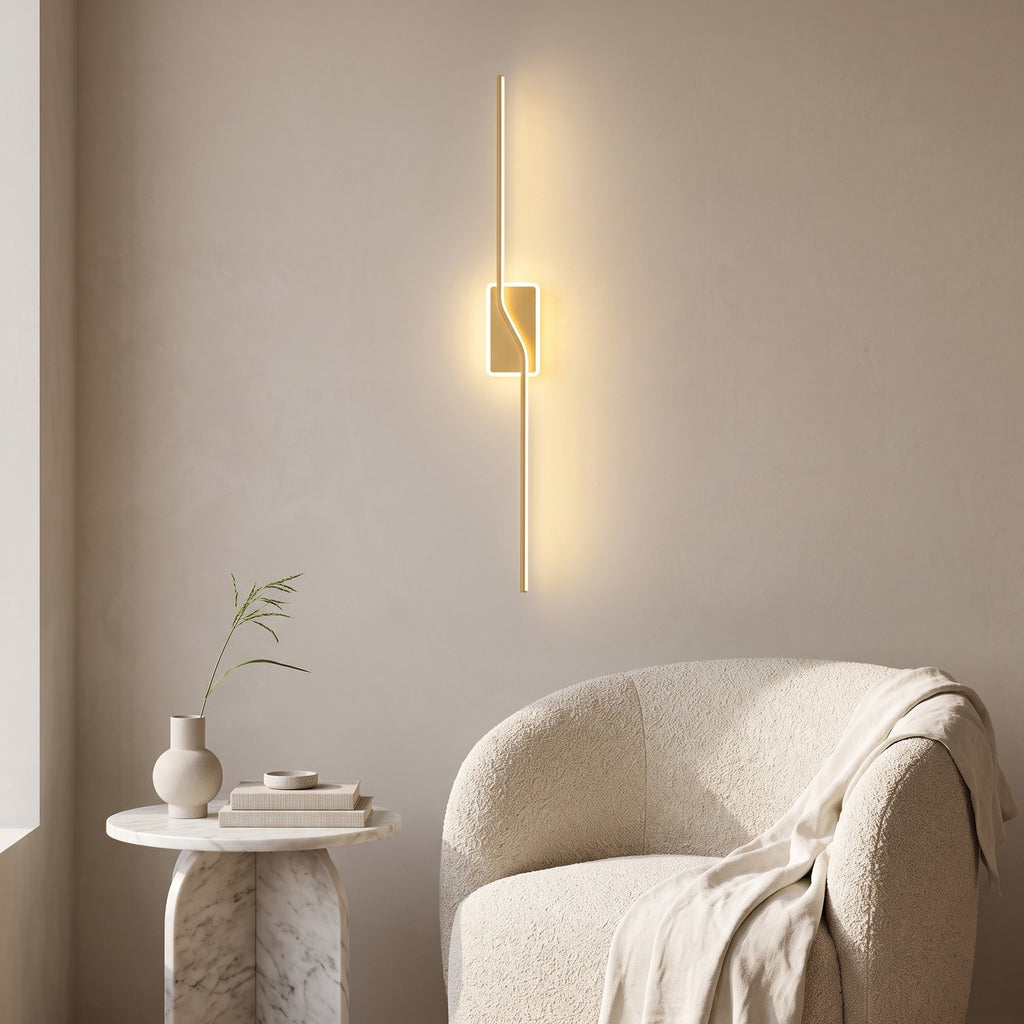 Slim Linear LED Wall Light – Gold in a quiet reading corner above a boucle armchair