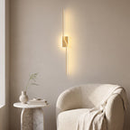 Slim Linear LED Wall Light – Gold in a quiet reading corner above a boucle armchair