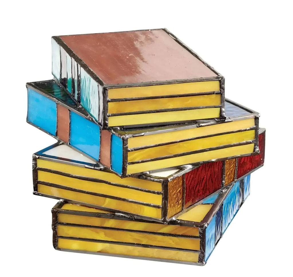 Vintage stained glass table lamp shaped like a stack of colorful books with yellow, blue, and red textured glass panels.