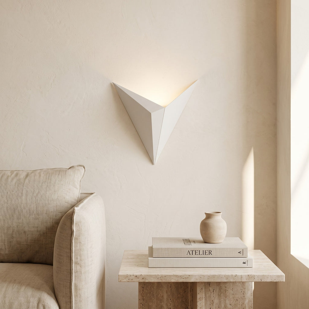 Triangle LED Wall Light in white, mounted above a travertine console in a bright living room