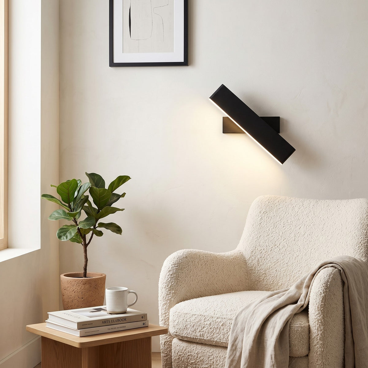 Up Down LED Wall Light – Black in a quiet reading corner above a boucle armchair