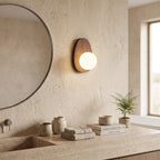 Walnut Wood Wall Light in a spa-like bathroom beside a large round mirror and stone vanity