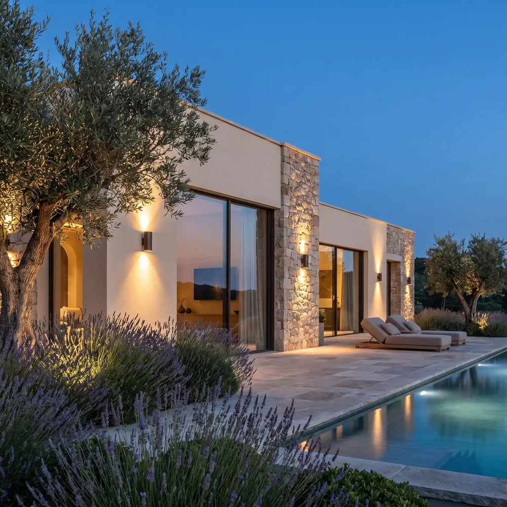 Outdoor wall lights on a stone villa facade at dusk
