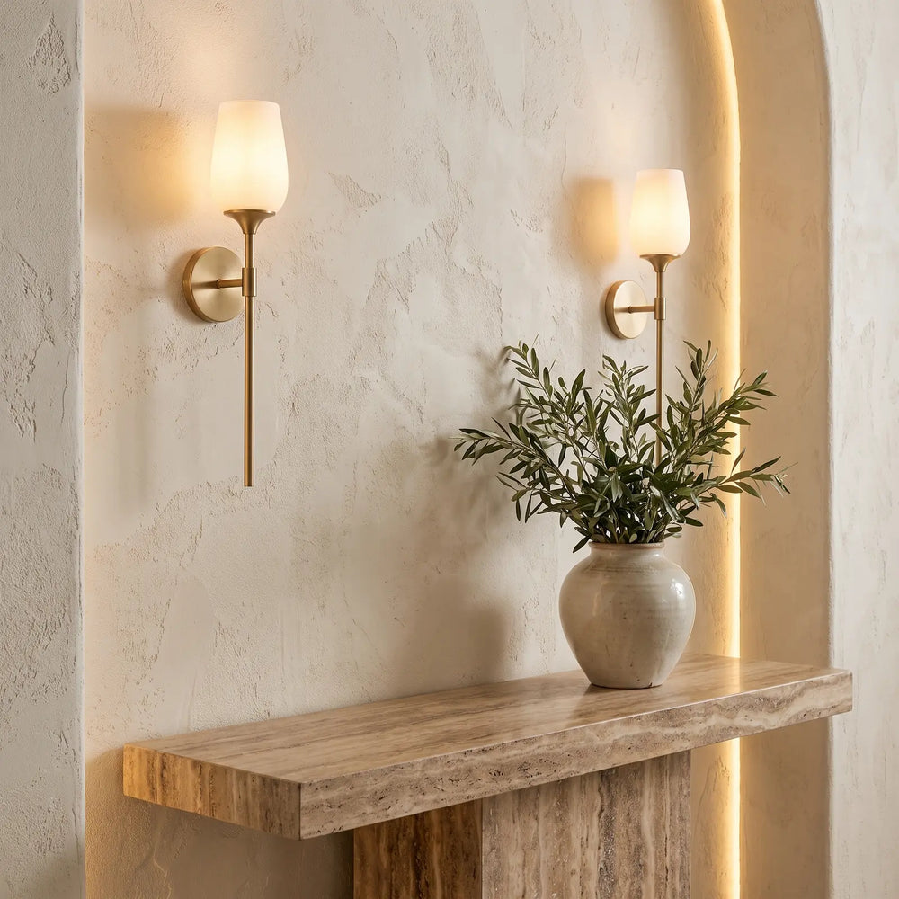 Brass and glass wall lights on a cream plaster wall